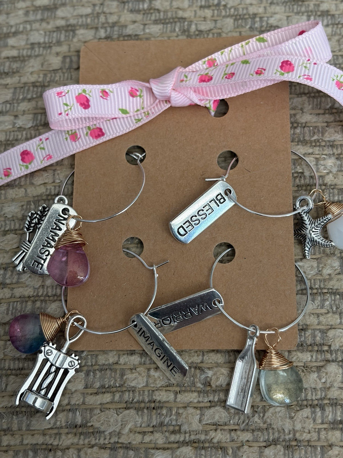 Handmade glass bottle charms featured in a bracelet with unique decorative elements and a pretty ribbon.